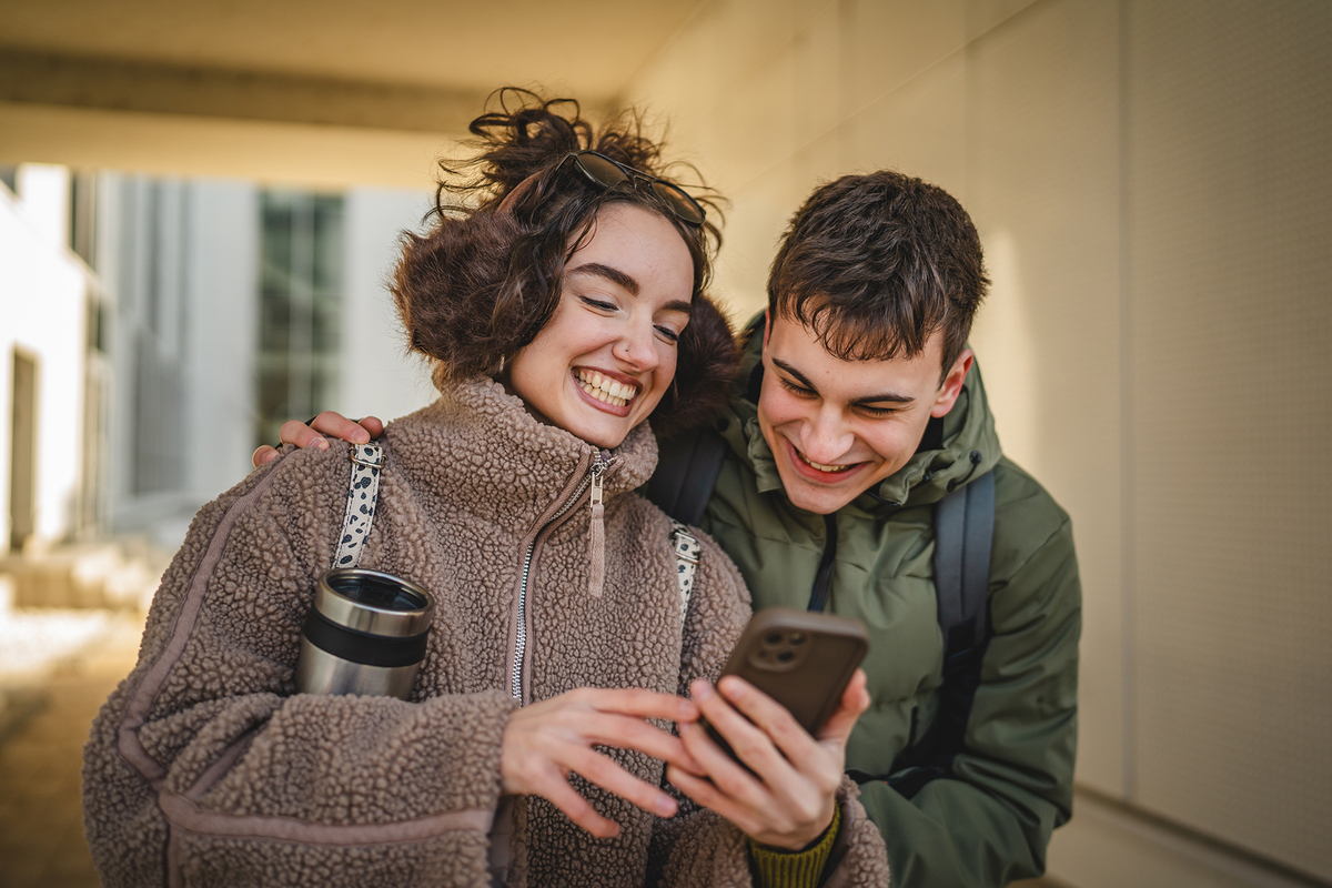 Para na zewnątrz z telefonem w ręce.
