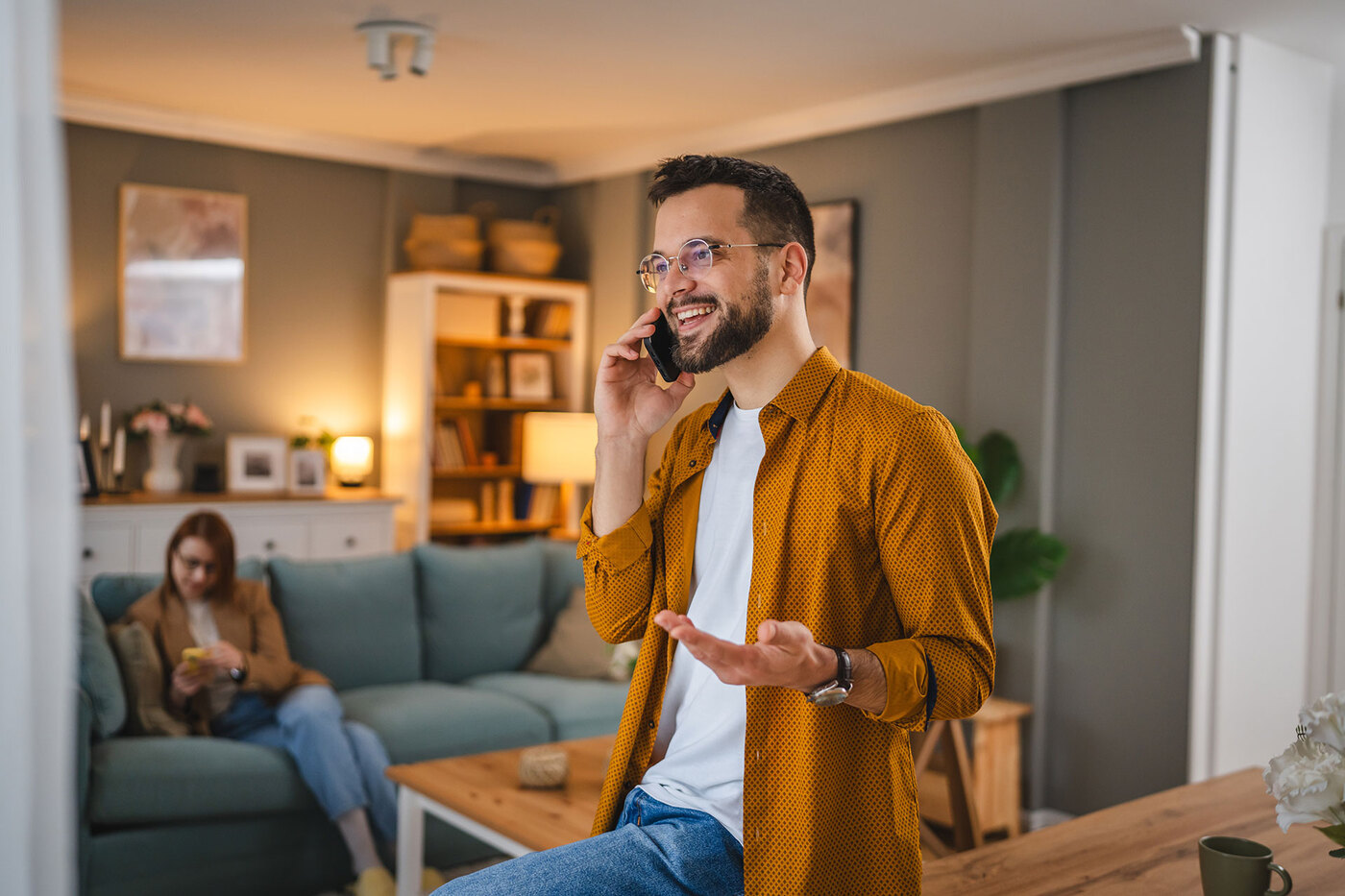 Mężczyzna rozmawia przez telefon w salonie.