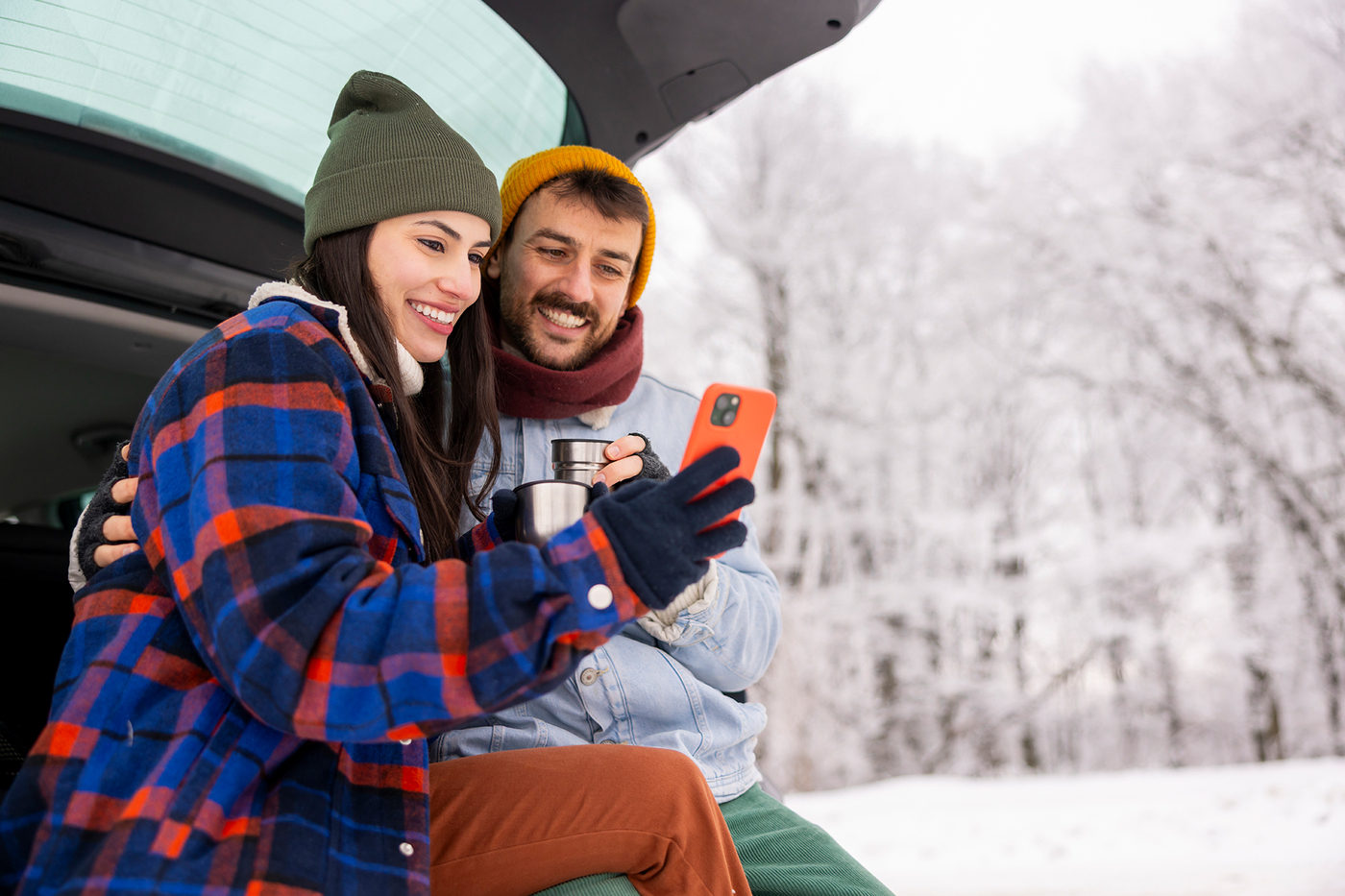 Kobieta i mężczyzna rozmawiają przez telefon podczas pobytu w górach.