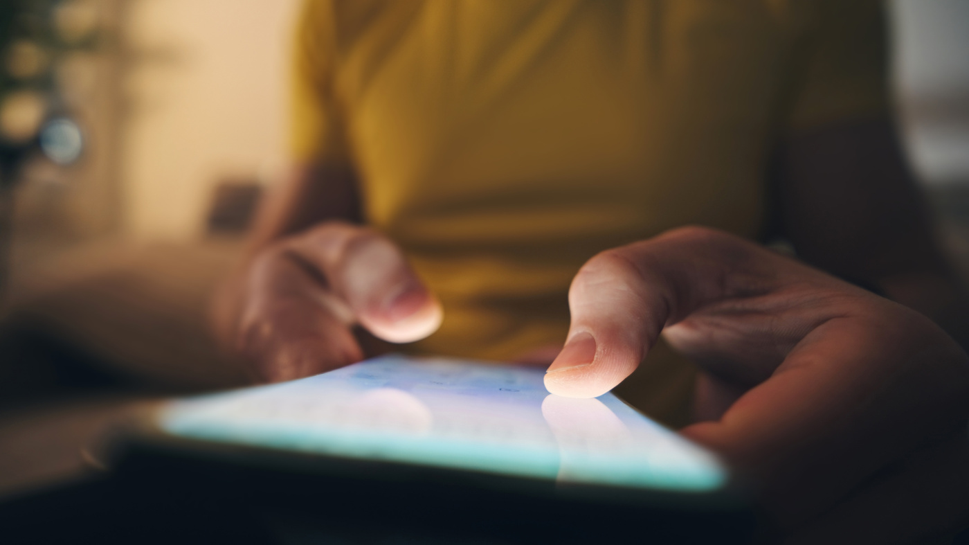 Osoba trzyma telefon z włączonym ekranem.