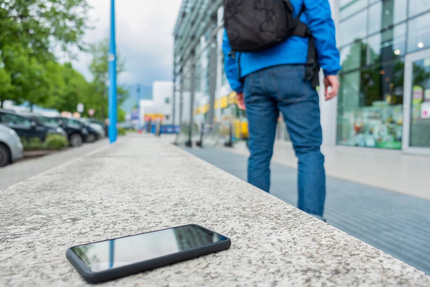 Telefon pozostawiony przez przechodnia leży na miejskim murku