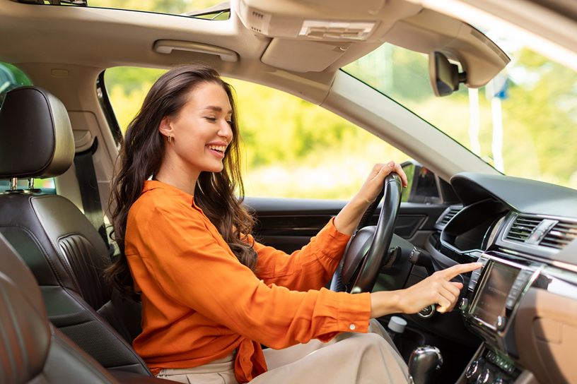 Kobieta w samochodzie obsługuje panel.