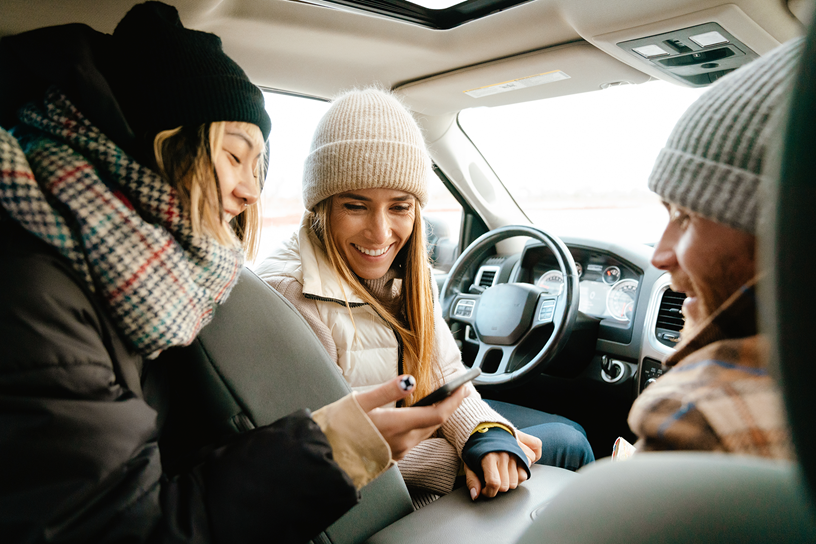 Rodzina w samochodzie patrzy na telefon.