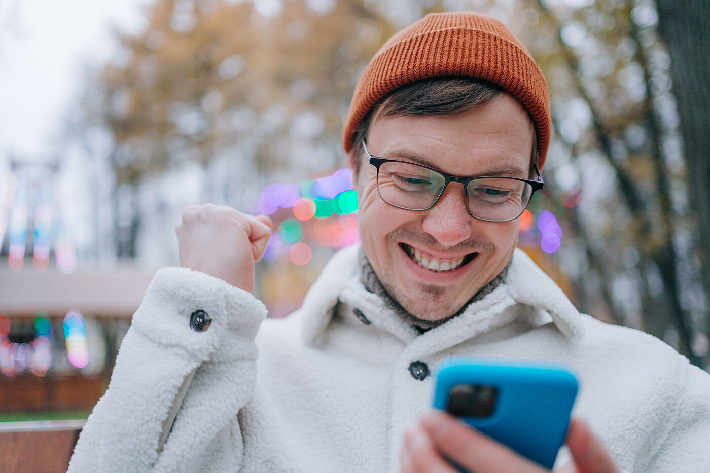 Mężczyzna w świątecznej scenerii patrzy na telefon.